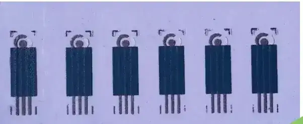 An array of screen-printed three-electrode sensor strips on a purple substrate.